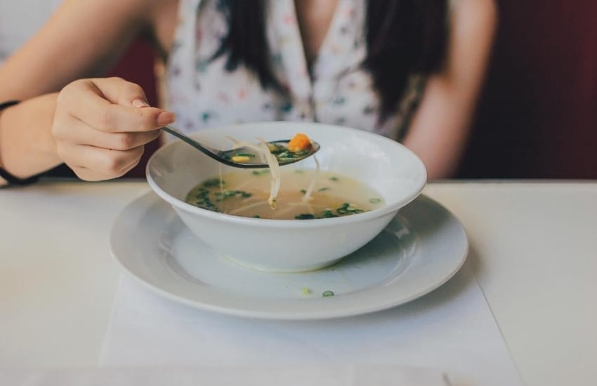 Woman with a bowl of vegetable soup