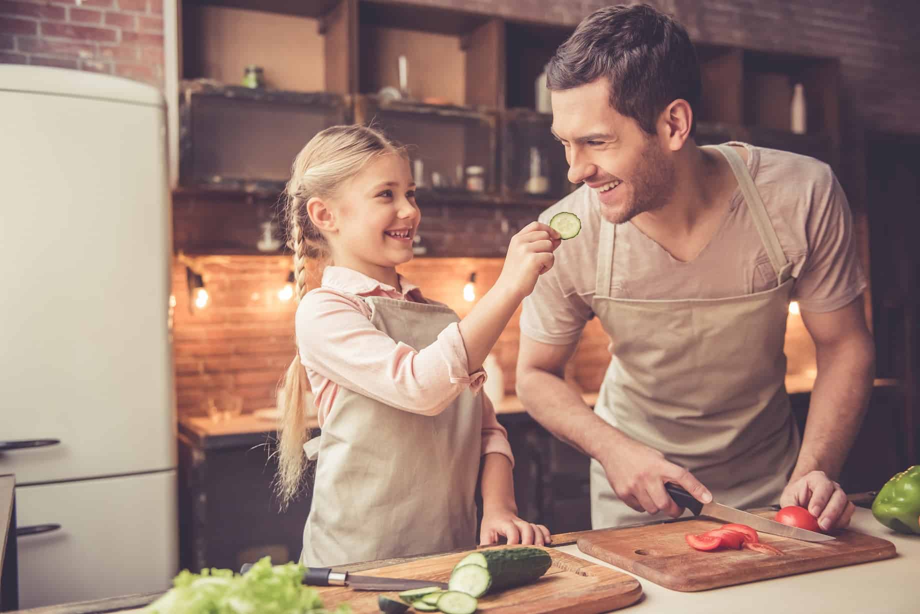Young girl cooking with adult male